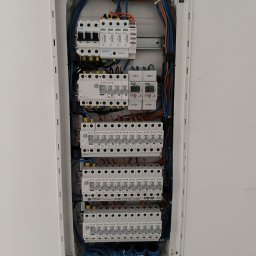 El.kat Volodymyr Vykhovanskyi - Rozdzielnica elektryczna w białej obudowie, widoczne zabezpieczenia, przewody w różnych kolorach, listwy zaciskowe. Instalacja schludna i uporządkowana.
