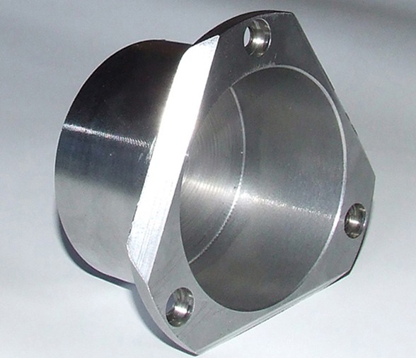 Metalowy detal z widocznymi śladami obróbki skrawaniem, z trzema otworami montażowymi na kołnierzu.