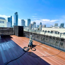 Firma Handlowo Usługowa ŁUKASZ SZLASKI - Tarasy kompozytowe po umyciu ciśnieniowym z widokiem na panoramę miasta w słoneczny dzień.