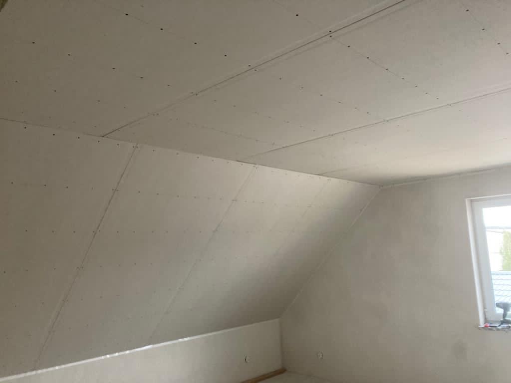 Poddasze w Sulęczynie z ukończonym montażem płyt na ścianach i suficie, widoczne łączenia i wkręty, przygotowane do dalszych prac wykończeniowych, okno w prawym rogu.