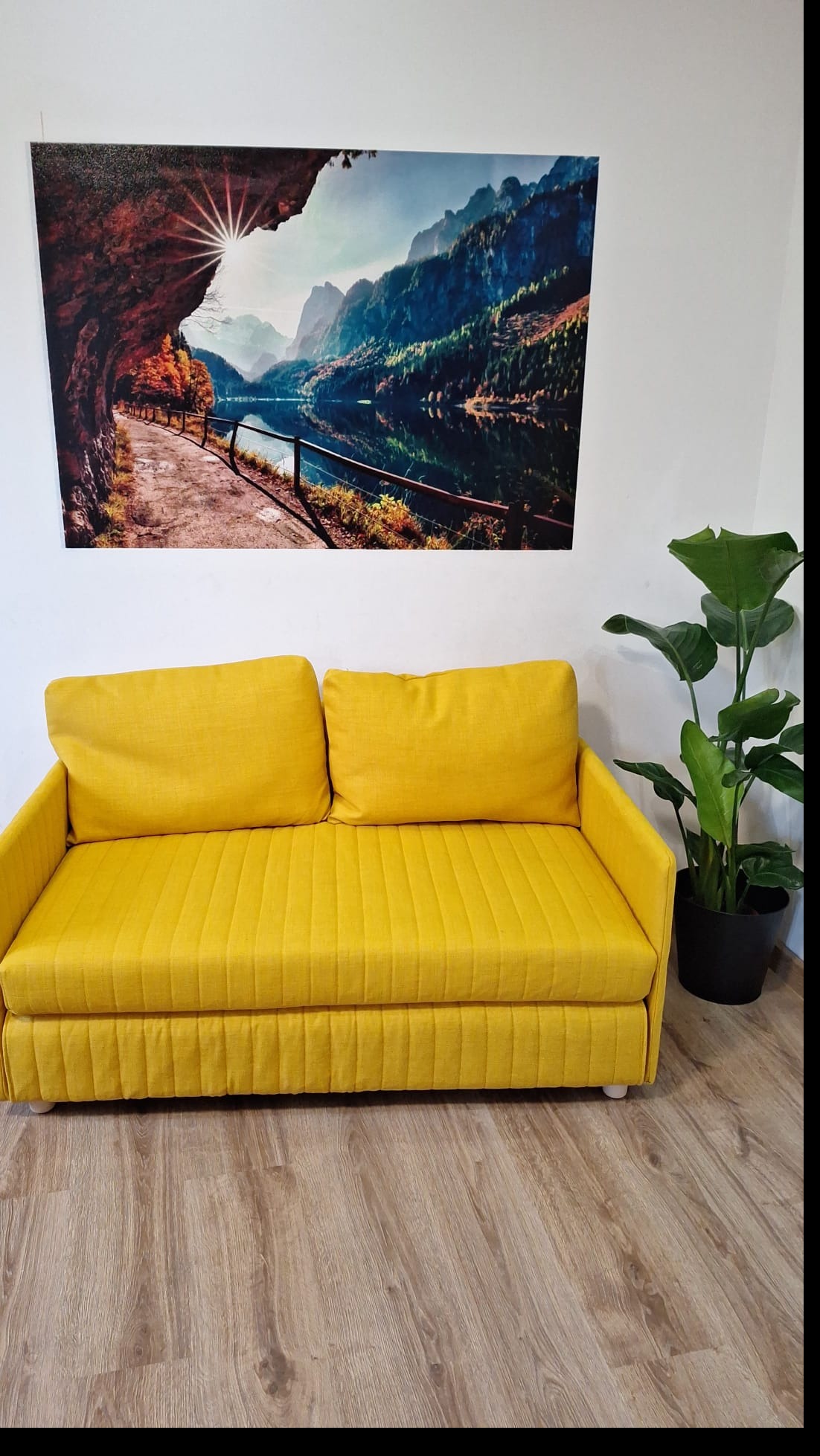 Malowniczy druk na ścianie w małym salonie.