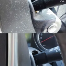 Detail ujęcia wnętrza samochodu: zakurzona kolumna kierownicy i przełącznik wycieraczek z widocznymi zabrudzeniami.