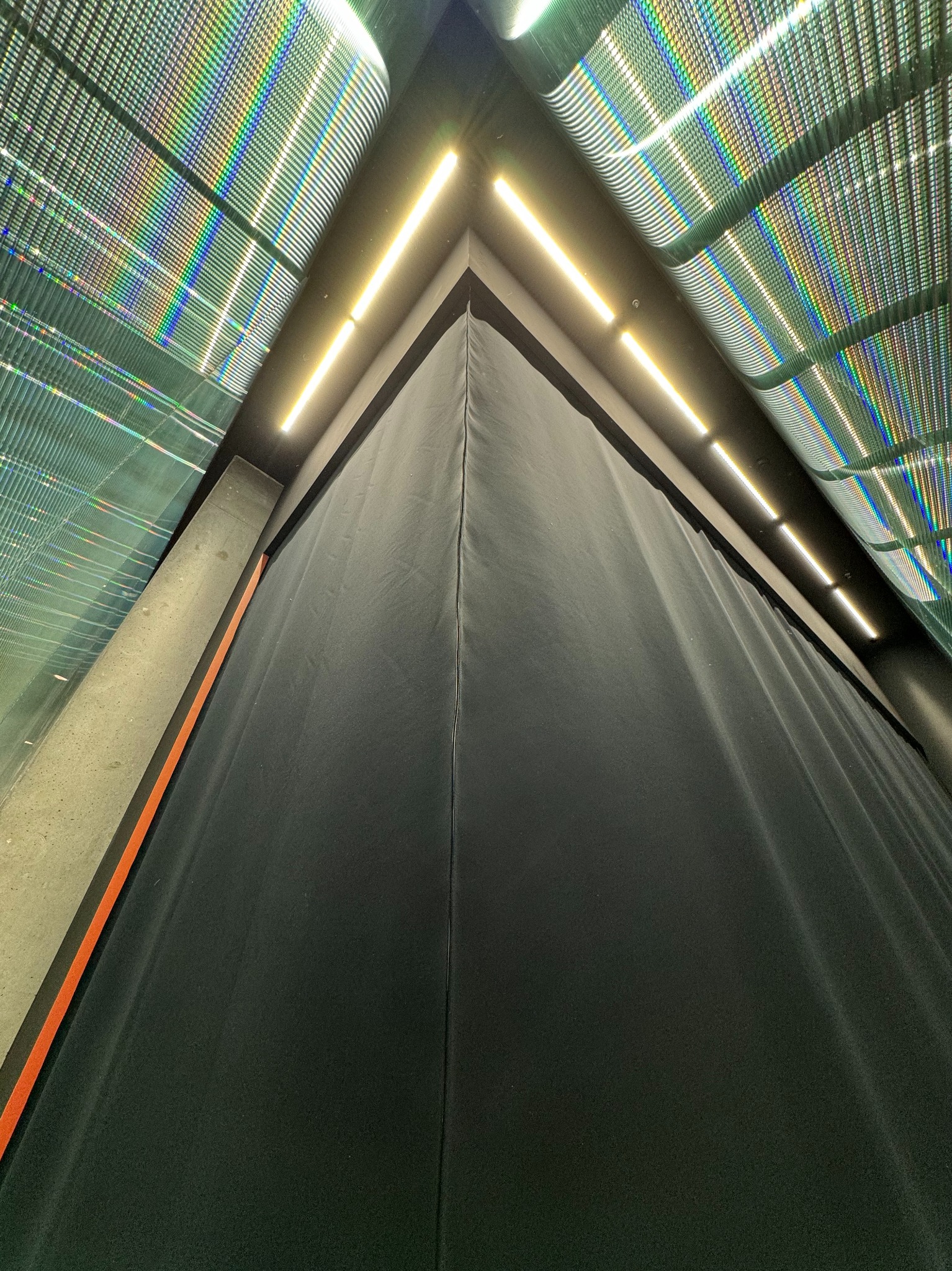 Czarna, trudnopalna zasłona typu Blackout w Radomiu, widziana z dołu, z oświetleniem LED i elementami dekoracyjnymi sufitu.