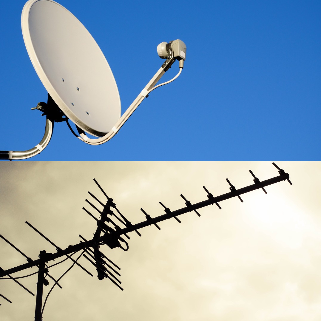 Antena satelitarna i antena naziemna skierowane w niebo, widoczne z dołu.