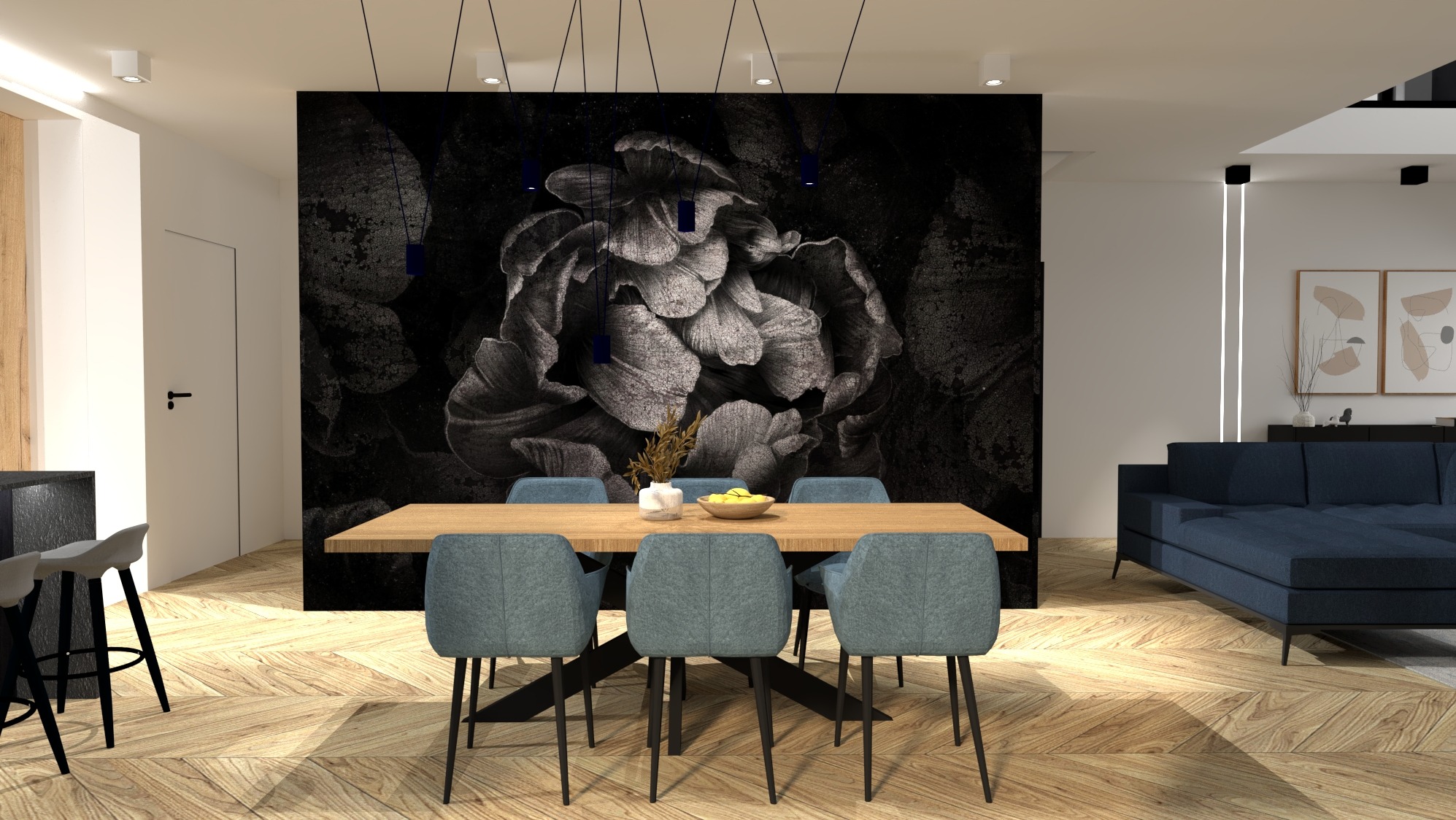 Jadalnia w nowoczesnym stylu z drewnianym stołem, szarymi krzesłami i fototapetą z motywem kwiatowym na ścianie. Nad stołem zwisają minimalistyczne lampy. W tle widoczny salon z granatową sofą...