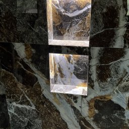 Osoba prywatna - Wykończona ściana z ciemnego, żyłkowatego marmuru z dwoma wnękami oświetlonymi od góry, tworzącymi dekoracyjny element.