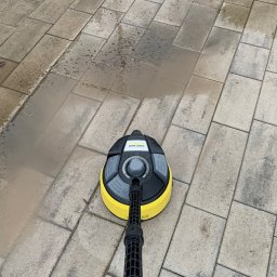 LFant Robert Mirowski - Czyszczenie kostki brukowej myjką ciśnieniową Kärcher z okrągłą szczotką: widoczna różnica między umytą a brudną powierzchnią.