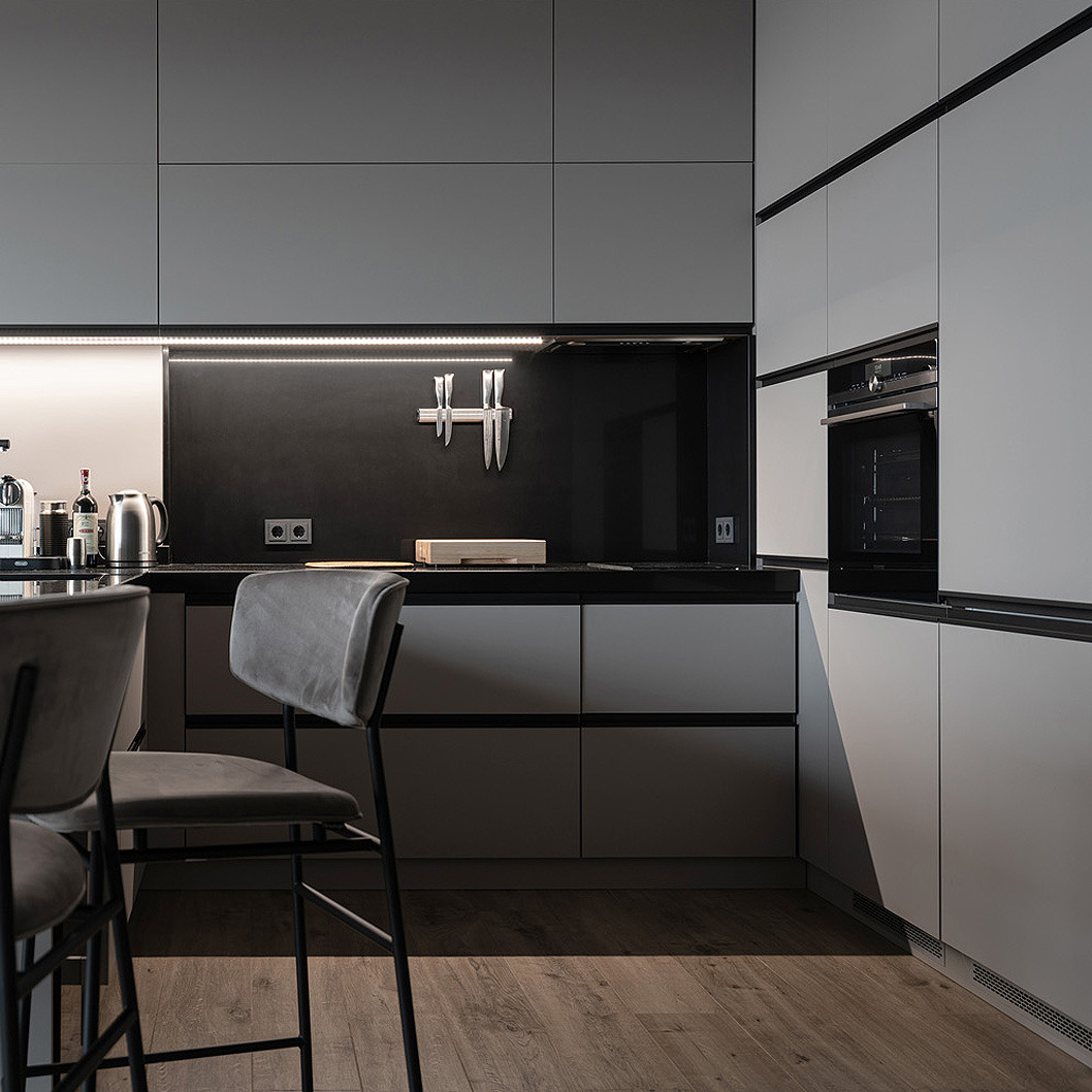 Nowoczesna kuchnia w odcieniach szarości z minimalistycznymi frontami szafek, oświetleniem LED podszafkowym i magnetycznym uchwytem na noże na czarnej ścianie nad blatem. Widoczne dwa krzesła...