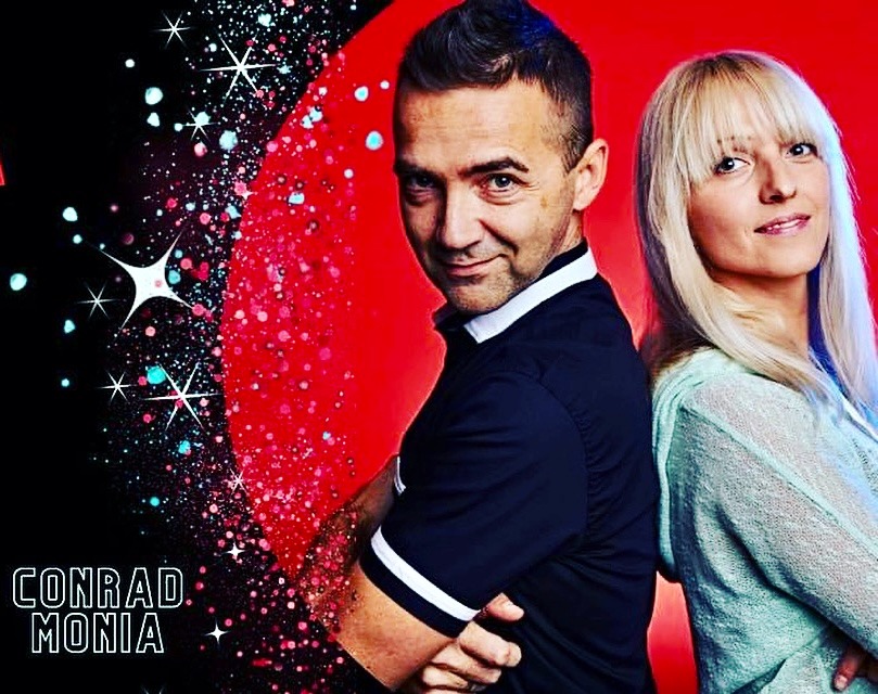 Portret dwojga instruktorów z nazwą 'CONRAD MONIA' na tle czerwono-czarnym z motywem gwiazd i brokatu.