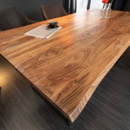 Mystictree - Stół z blatem z litego drewna o nieregularnym kształcie krawędzi, stylizowany na rustykalny, ustawiony w jadalni w Cerkwicy. Na blacie filiżanka kawy i gazeta.