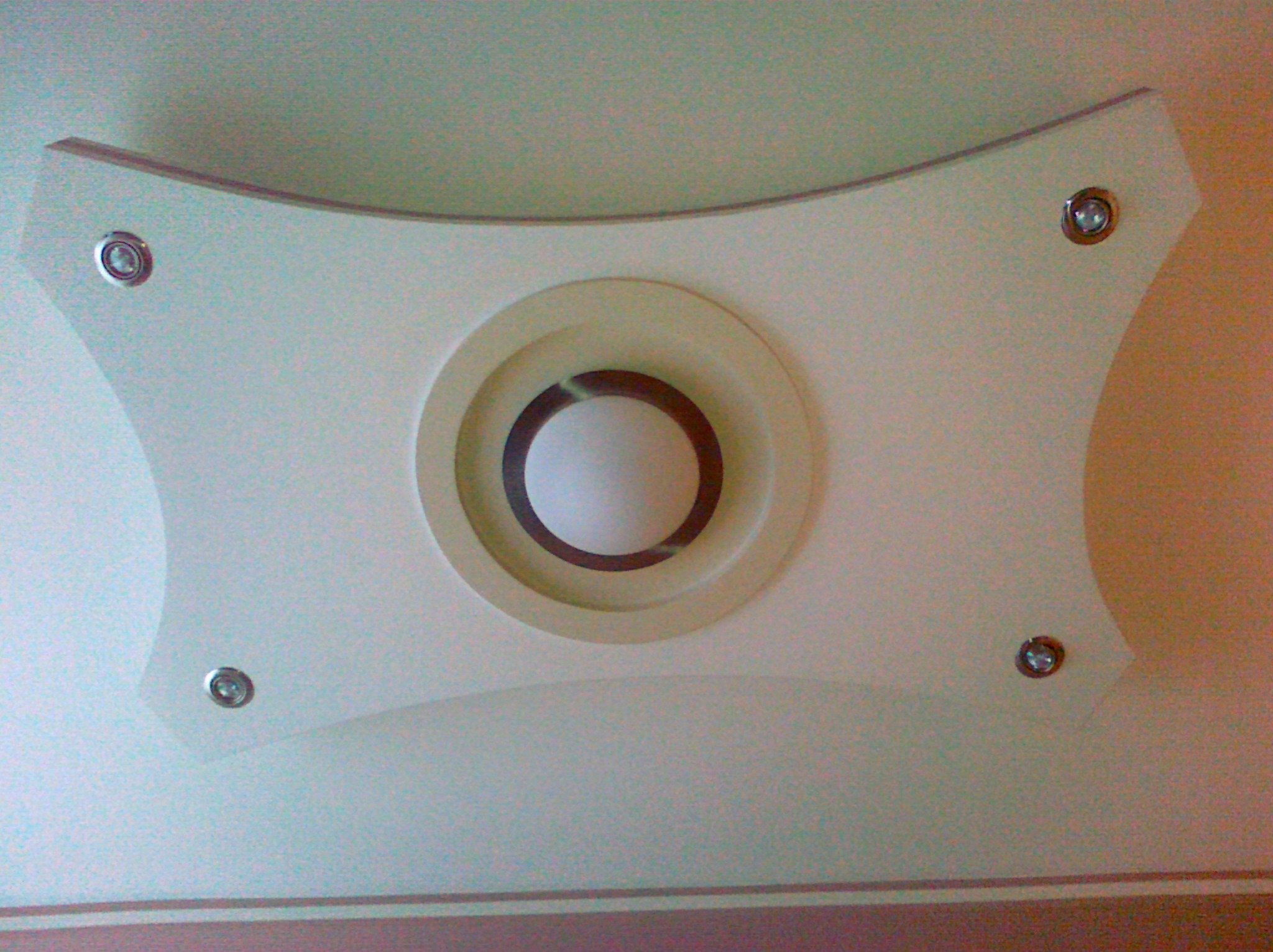 Dekoracyjny sufit podwieszany z centralnym okręgiem i czterema punktami mocowania, widok od dołu.