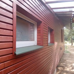 Łukasz Mazurek - elewacja z ociepleniem - modrzew syberyjski, małe zadaszenie z poliwęglanu pomiędzy budynkami.