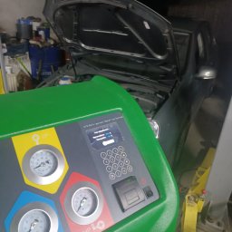 BREMS - Urządzenie do obsługi klimatyzacji samochodowej Viaken z widocznymi manometrami i panelem sterowania, podłączone do samochodu z otwartą maską w warsztacie.