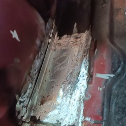 BREMS - Fragment skorodowanej karoserii samochodu w Serbinowie, przygotowywanej do naprawy blacharskiej z widocznymi śladami korozji i resztkami starej powłoki lakierniczej.