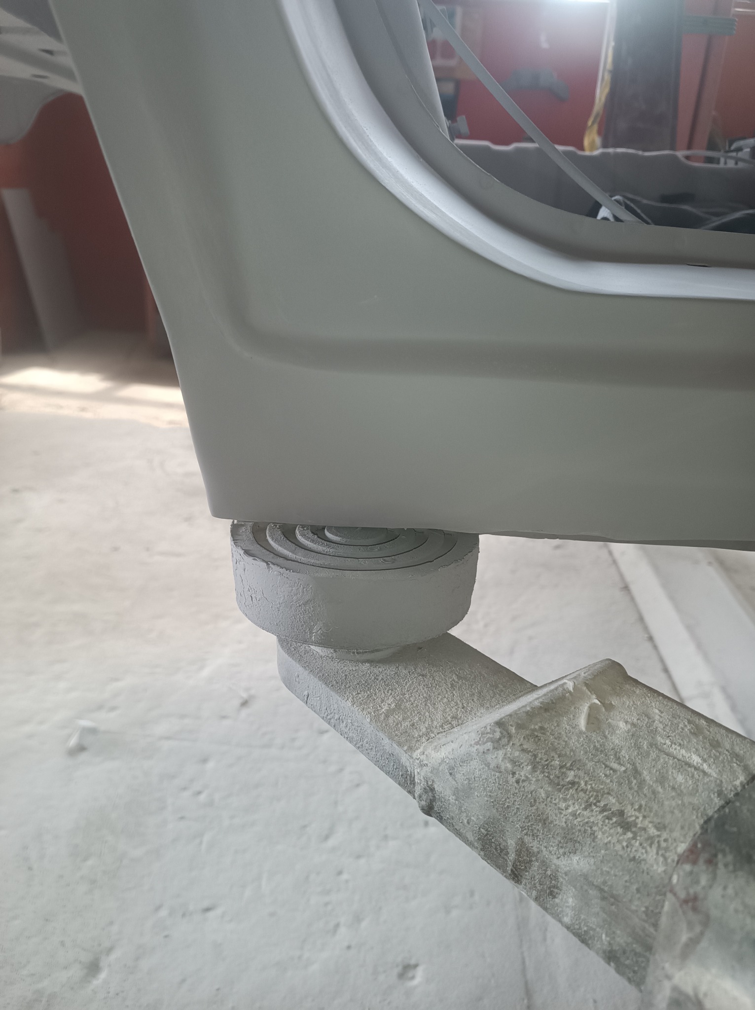 Podwozie samochodu na podnośniku warsztatowym po piaskowaniu, widoczne ślady piasku na konstrukcji podnośnika.