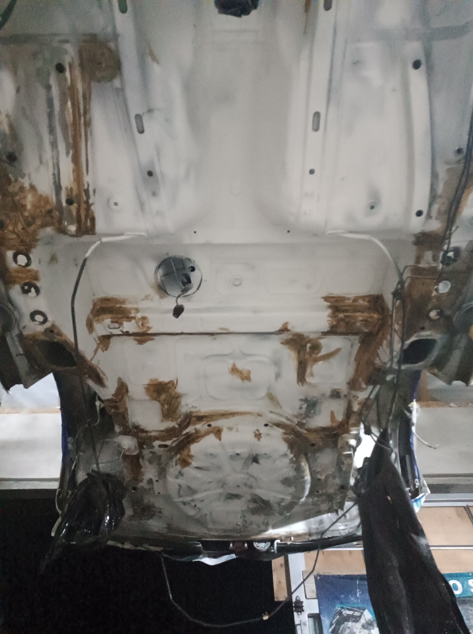 Spód samochodu w trakcie prac antykorozyjnych w Serbinowie, widoczne ślady rdzy i świeżo nałożony podkład.