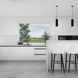 Format Przestrzeni AGNIESZKA BRUŚ-BADLAK - Minimalistyczna, biała kuchnia z czarnymi akcentami: okrągłe płytki nad blatem, trzy białe hokery przy wyspie, widok na zielone pole przez okno.