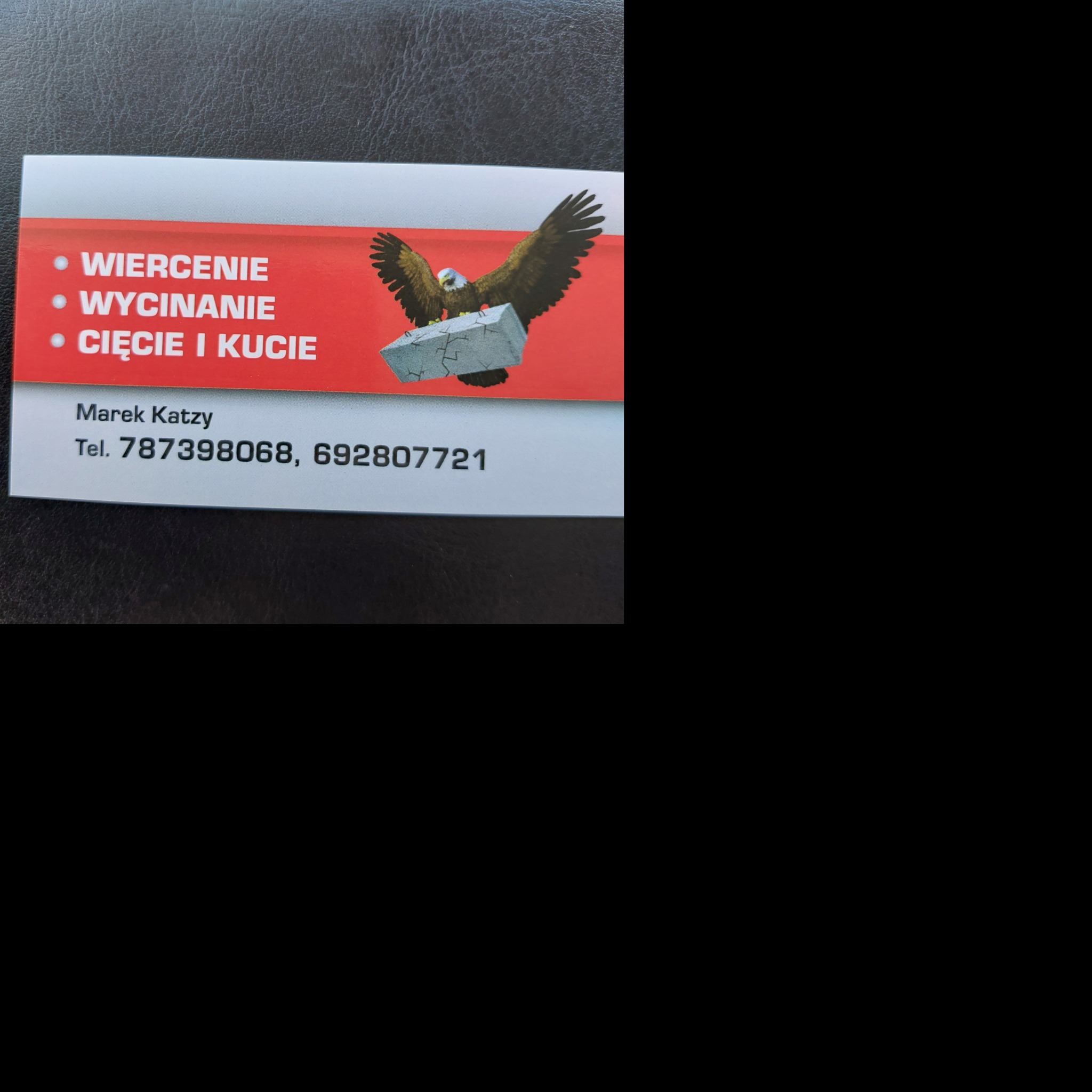 Wizytówka firmy budowlanej oferującej wiercenie, wycinanie, cięcie i kucie, z grafiką orła niosącego blok kamienny.