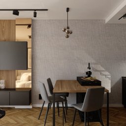 Merlin Interior - Nowoczesne wnętrze mieszkania z otwartą kuchnią, drewnianym parkietem, czarnymi meblami i oświetleniem punktowym.