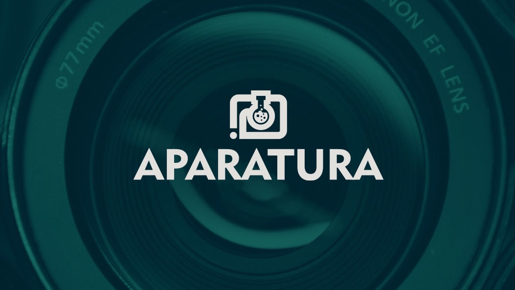 Minimalistyczne logo z motywem aparatu i kolby laboratoryjnej na tle obiektywu Canon EF.