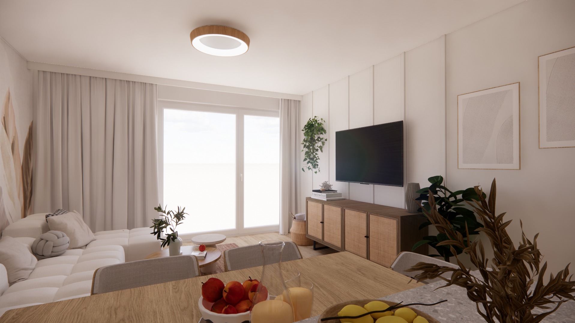Jasne wnętrze salonu z telewizorem i rattanową komodą pod nim, minimalistyczne obrazy na ścianie, biała sofa modułowa przy oknie, drewniany stół z owocami na pierwszym planie.