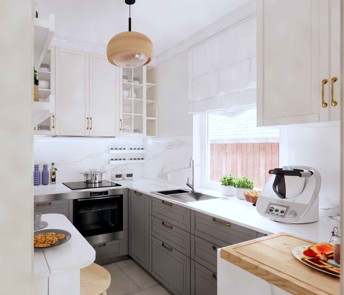 Jasna kuchnia w stylu klasycznym z szarymi szafkami, marmurowym blatem i nowoczesnym robotem kuchennym Thermomix obok okna z roletą rzymską.