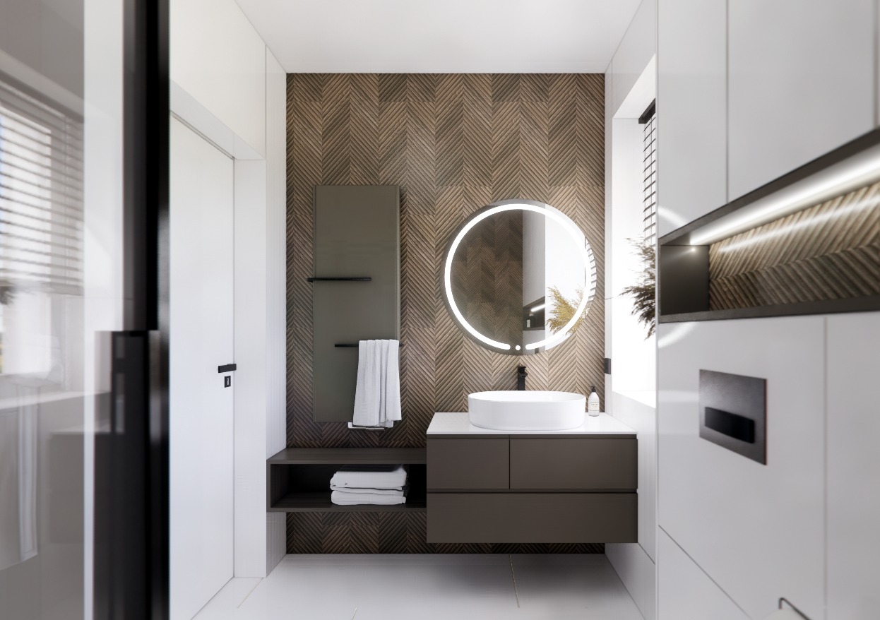 Nowoczesna łazienka z okrągłym lustrem z podświetleniem LED, brązowymi płytkami ułożonymi w jodełkę na ścianie, umywalką nablatową i grzejnikiem drabinkowym.