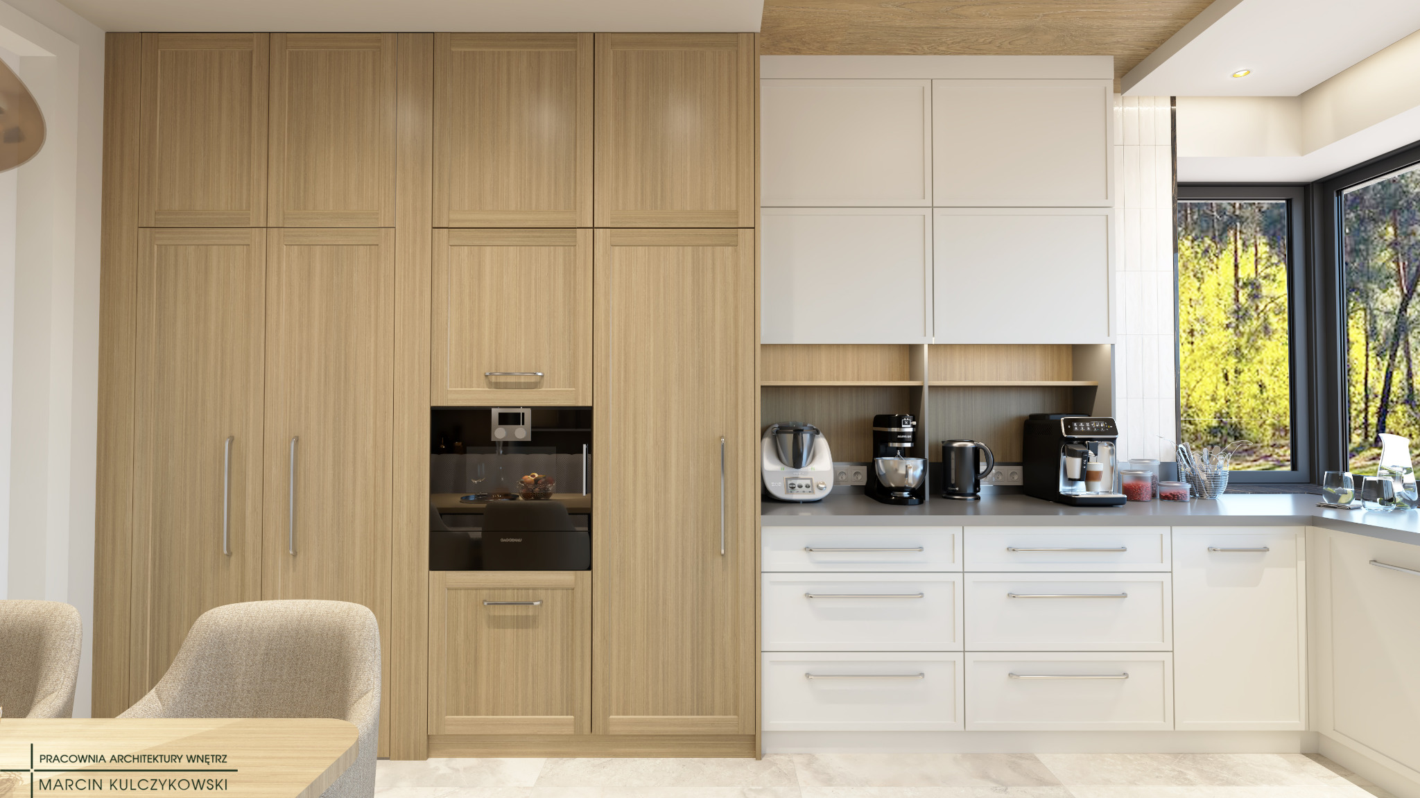 Jasna kuchnia z drewnianymi frontami szafek, wbudowanym piekarnikiem i białymi szafkami, okno z widokiem na zieleń, ekspresy do kawy na blacie.
