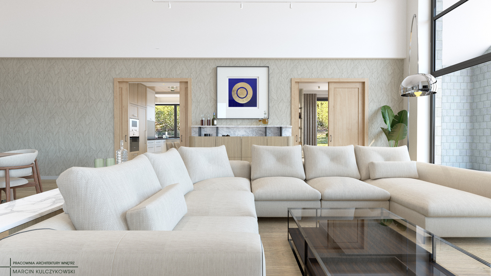 Jasny salon z narożną sofą, szklanym stolikiem kawowym, ścianą z tapetą w liście i widokiem na kuchnię oraz ogród przez otwarte drzwi.