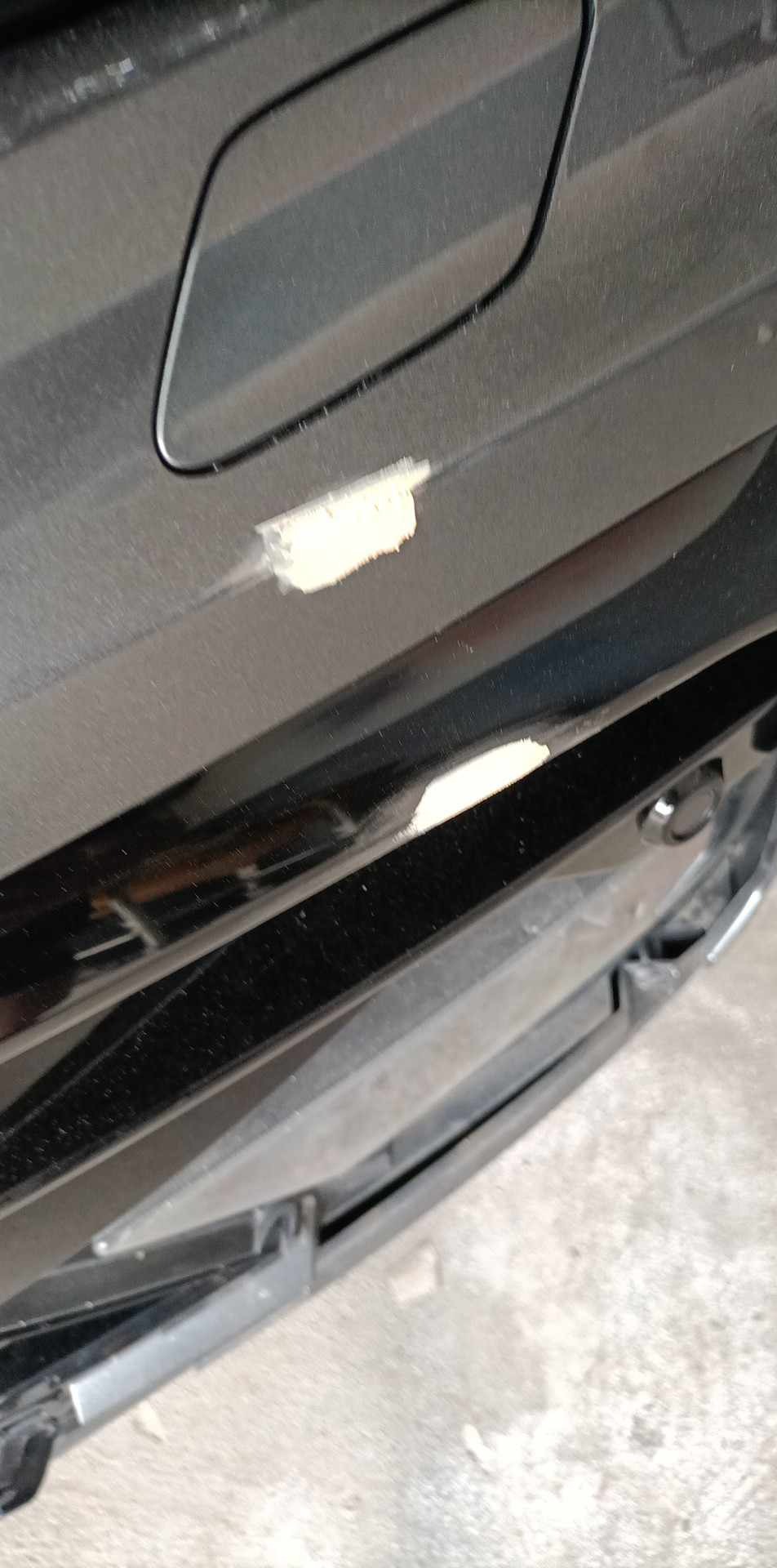 Uszkodzony lakier na czarnym samochodzie w Sitaniec, widoczne odpryski i zarysowania na karoserii.