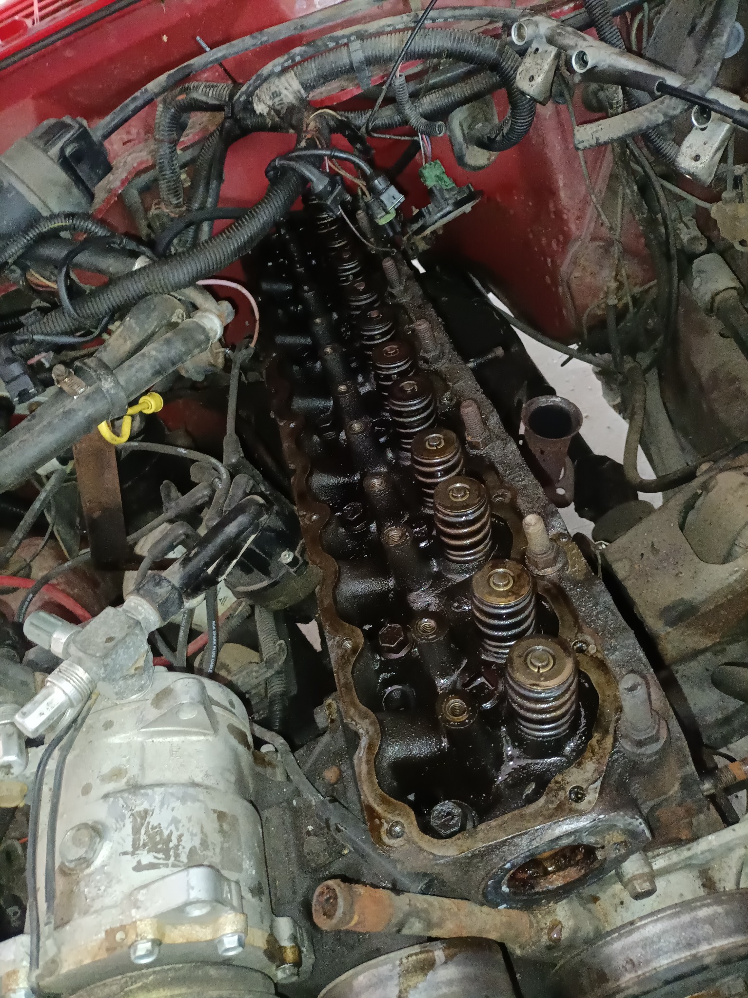 Otwarty silnik samochodowy z widocznymi sprężynami zaworowymi i przewodami, z bliska, w trakcie naprawy.