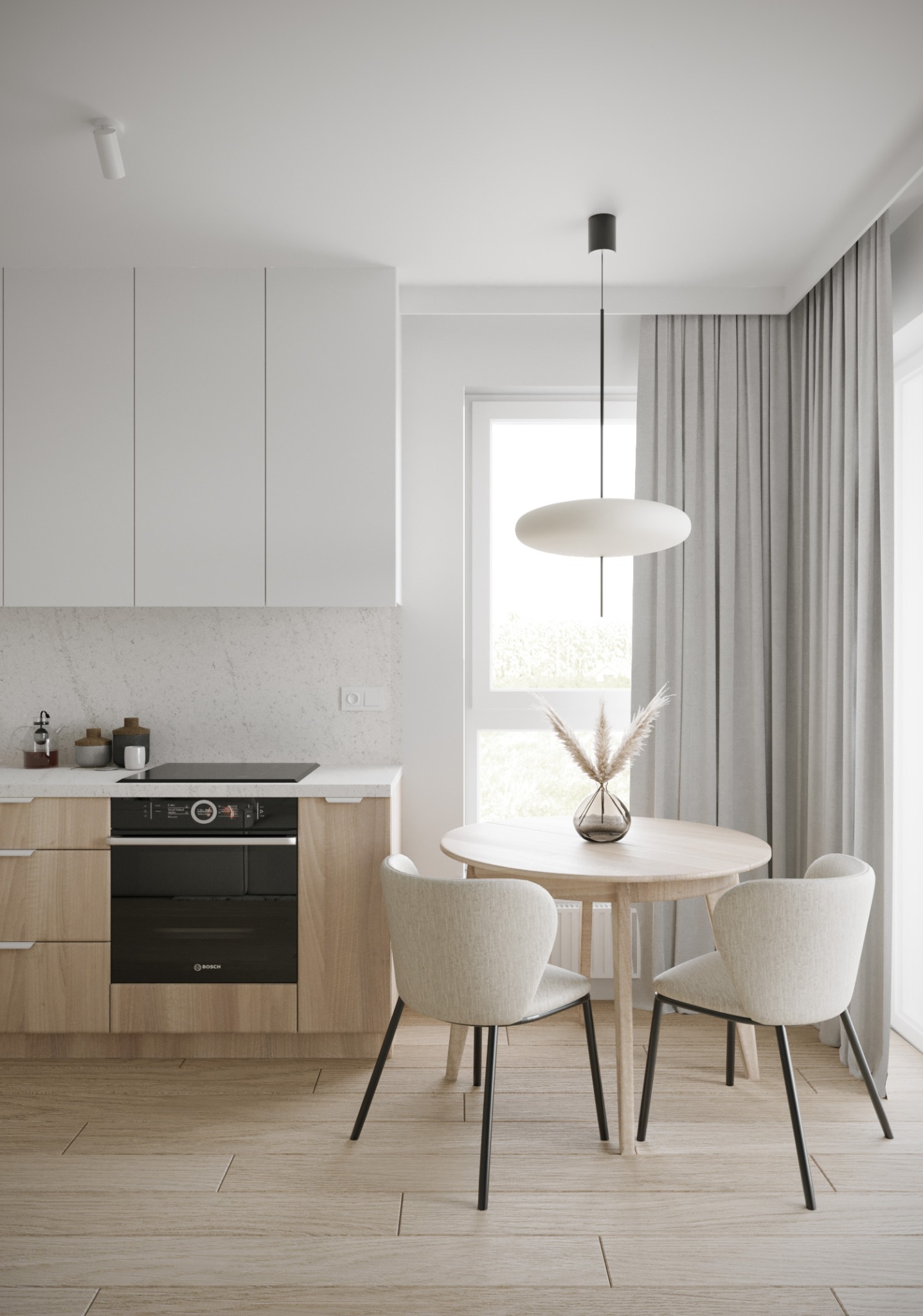 Jasna kuchnia z drewnianymi szafkami, białymi górnymi szafkami i okrągłym stołem z dwoma krzesłami, minimalistyczna lampa wisząca i dekoracyjna trawa pampasowa w szklanym wazonie na stole.