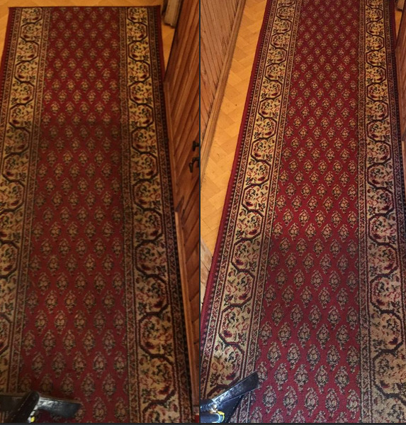 Czerwony dywan z wzorem, widoczna różnica w czystości między częścią wypraną a nie wypraną, drewniana podłoga i fragment ściany w tle.