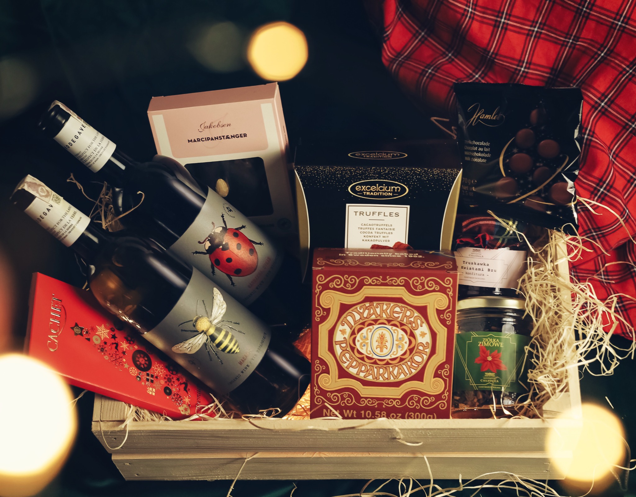 Skrzynka ogrodniczka z winem, słodyczami, konfiturą i herbatką zimową.