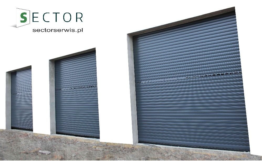 Trzy szare rolety w kasecie, zamontowane na elewacji budynku, z widocznym logo firmy w lewym górnym rogu.