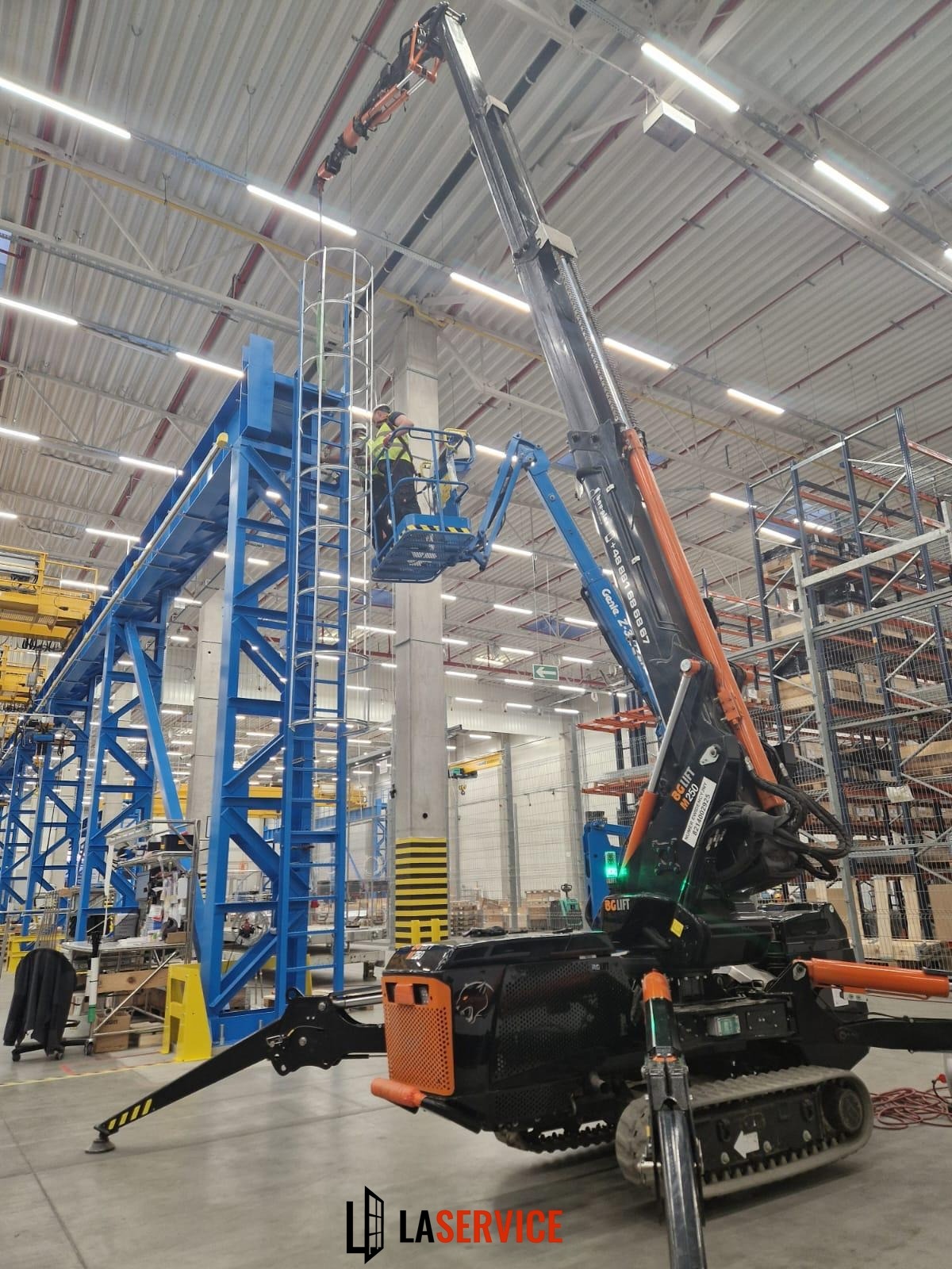 Specjalistyczny podnośnik koszowy BGLIFT M250 w hali magazynowej w Szczecinie, obsługiwany przez dwóch pracowników, przy montażu elementów konstrukcyjnych.