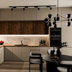 Och.Design - Nowoczesna kuchnia z drewnianymi akcentami, oświetleniem punktowym i okrągłym stołem jadalnym, widok na krajobraz za oknem.