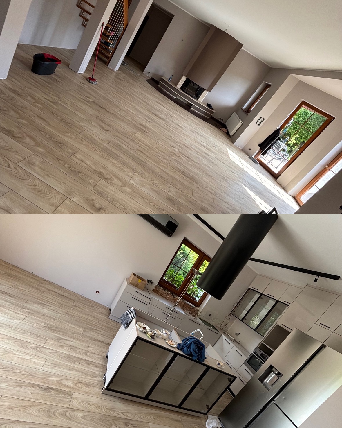 Ukończona podłoga w salonie i kuchni, widok z góry. Jasne panele ułożone w nowym domu. Biała kuchnia z oknem. Salon z kominkiem i schodami.