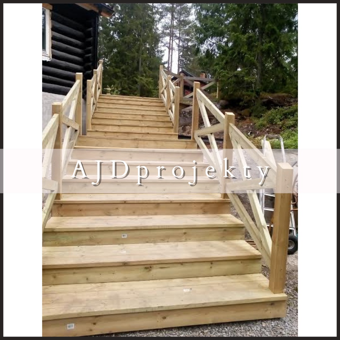 Drewniane schody zewnętrzne z balustradą prowadzące do domu z bali, widok z dołu, w tle drzewa i wózek transportowy.