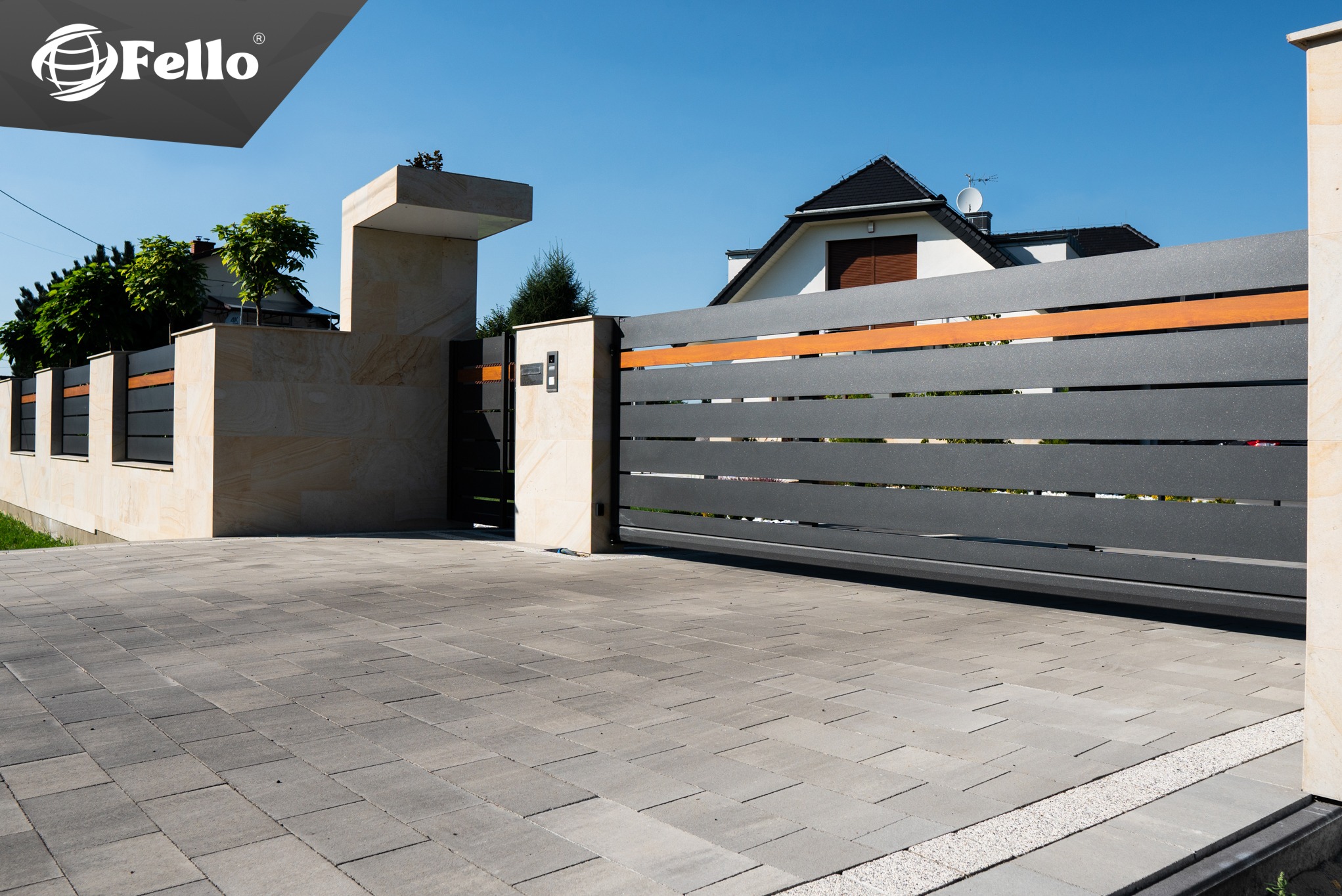 Nowoczesna, przesuwna brama wjazdowa 'SOLID' w kolorze grafitowym z poziomymi, drewnianymi akcentami, zamontowana przy posesji z kostki brukowej i kamiennego ogrodzenia.