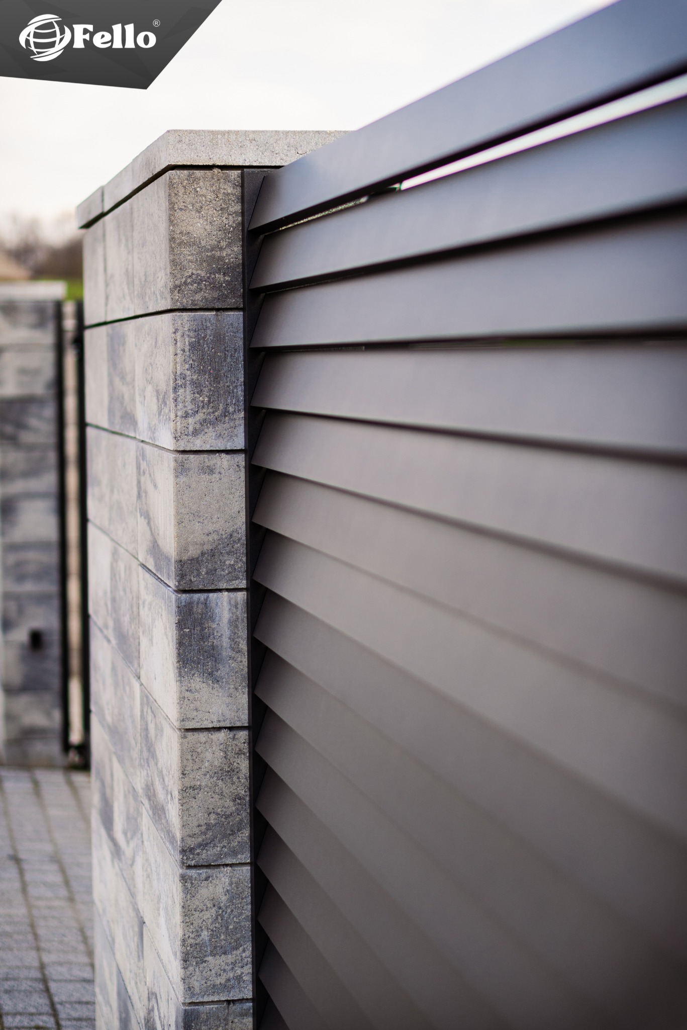 Szczegółowe ujęcie nowoczesnego ogrodzenia panelowego z szarego kamienia i metalowych, poziomych paneli, oświetlonych naturalnym światłem. Model FENDER.