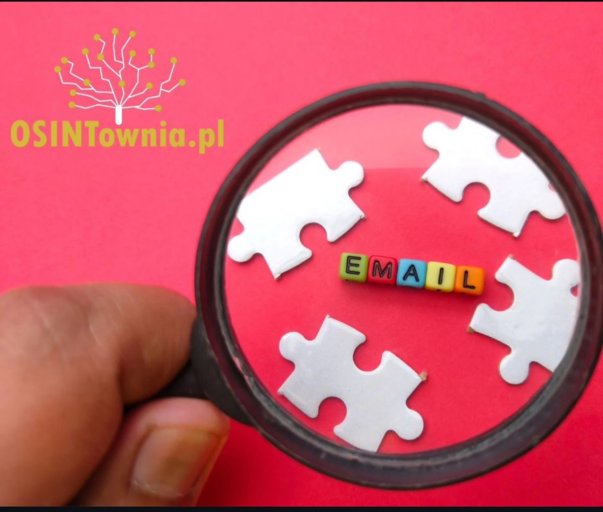 Powiększenie słowa 'EMAIL' z klocków wśród białych puzzli na różowym tle za pomocą lupy trzymanej w dłoni, logo OSINTownia.pl w lewym górnym rogu.