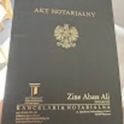 Czarne etui na akt notarialny z godłem Polski i napisem 'Akt Notarialny' w złotym kolorze, poniżej nazwa kancelarii notarialnej Zine Abass Ali.