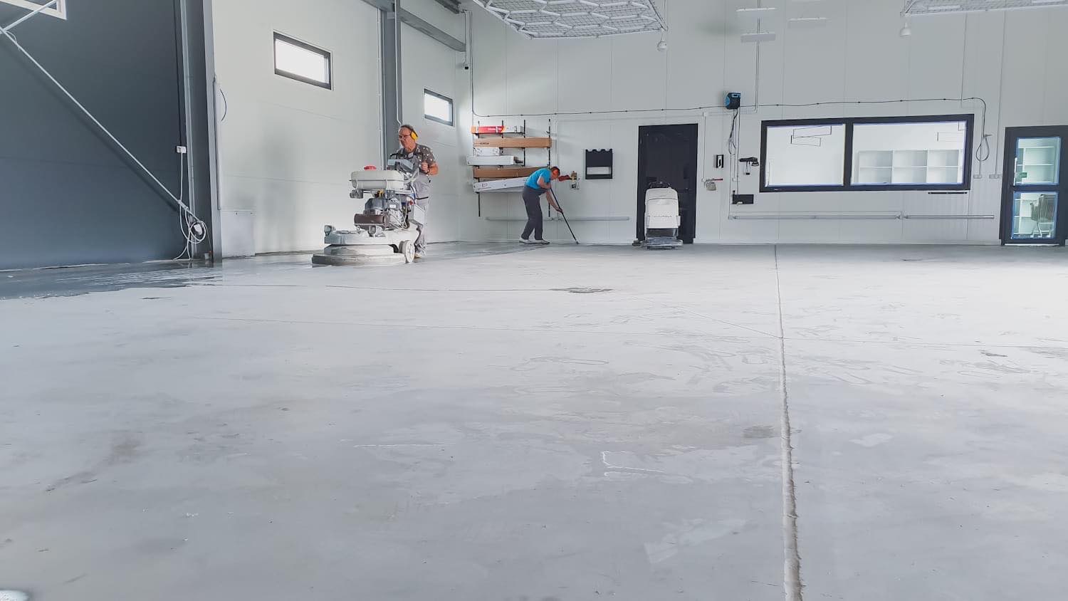 Posadzka przed usługą polerowania i zabezpieczania posadzki w studio detailingowym.