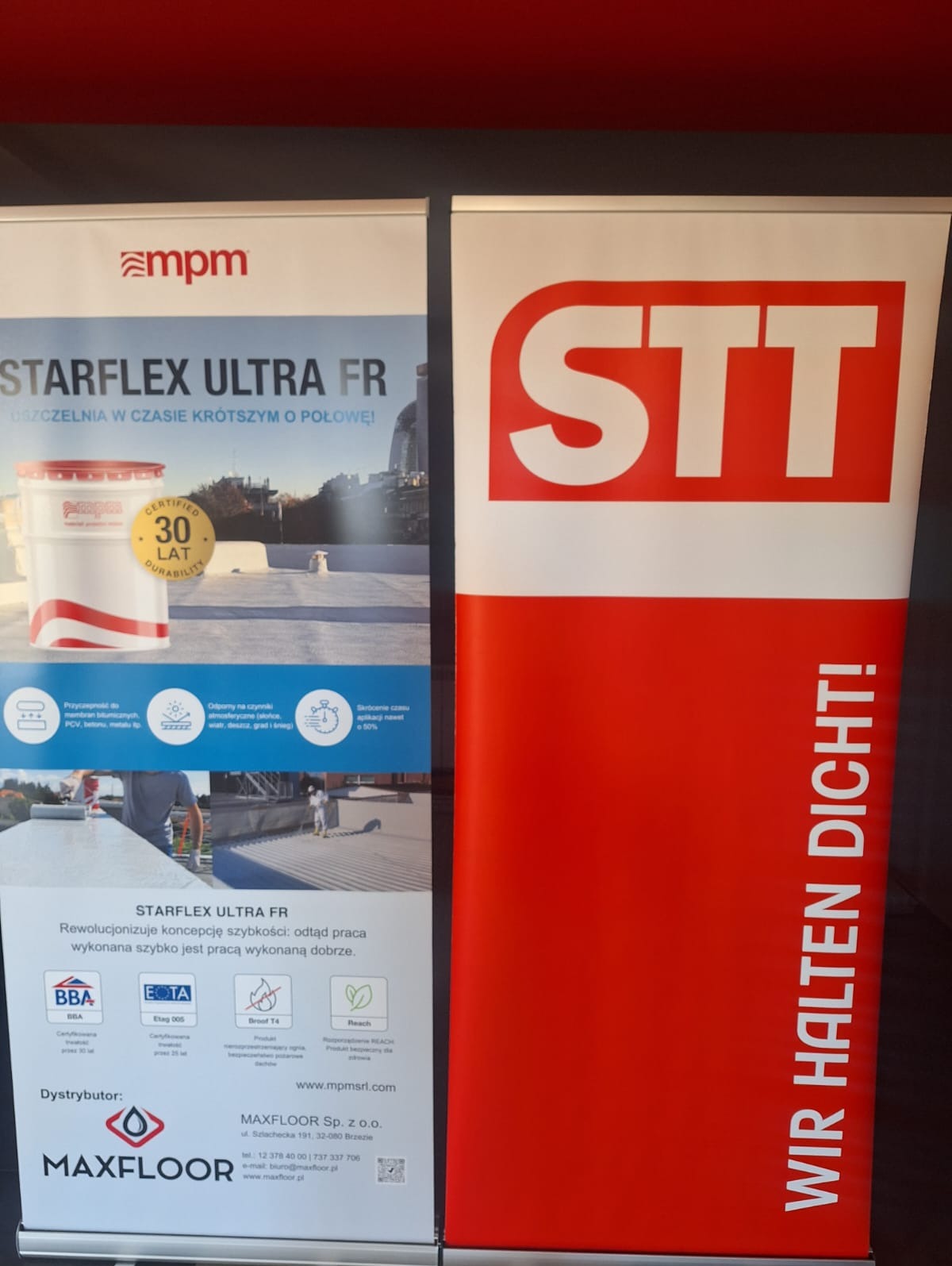 Dwa roll-upy reklamowe: jeden z logiem MPM i hasłem STARFLEX ULTRA FR, drugi z czerwonym tłem i napisem STT WIR HALTEN DICHT!, prezentujące produkty do uszczelniania.