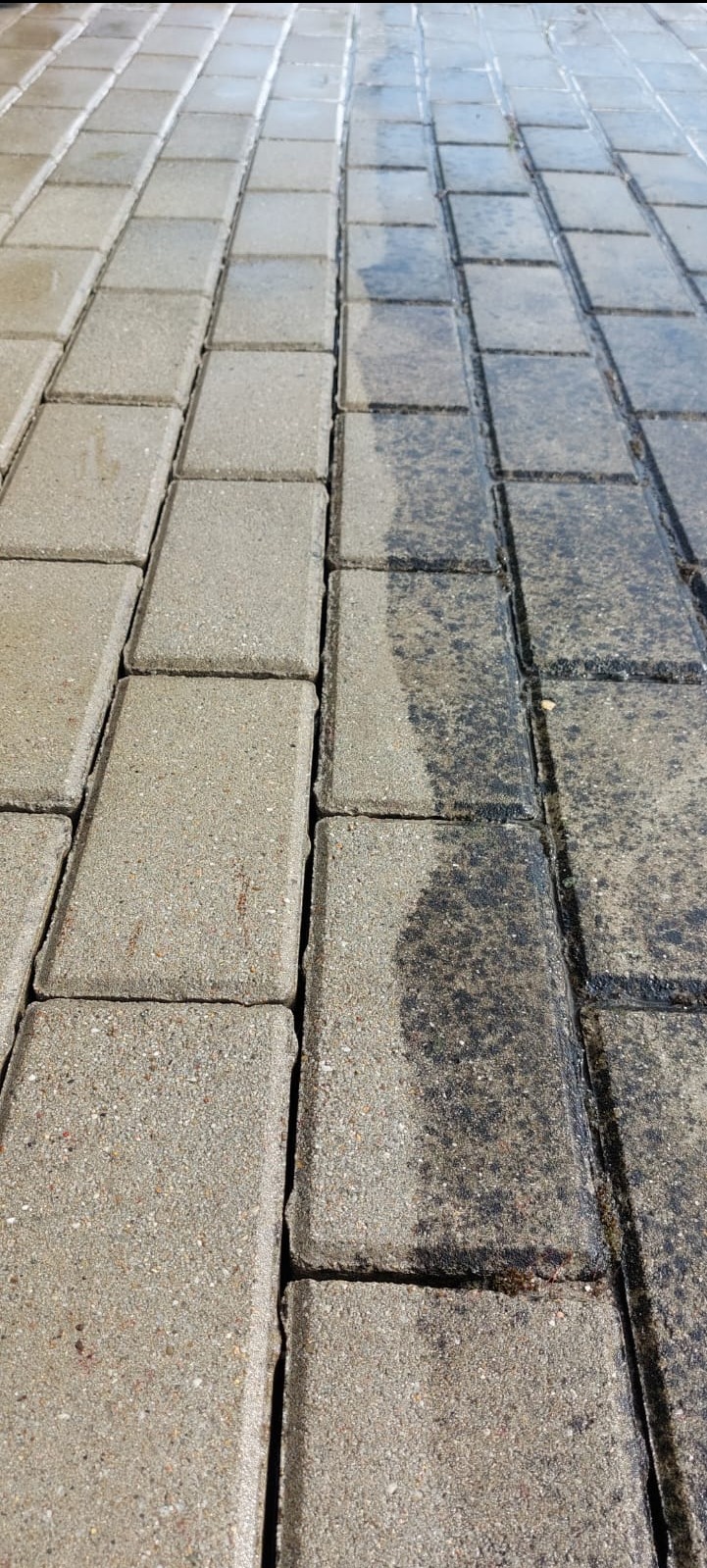 Fragment chodnika z kostki brukowej, po lewej stronie czysta, po prawej brudna, widoczna wyraźna różnica w kolorze i fakturze.