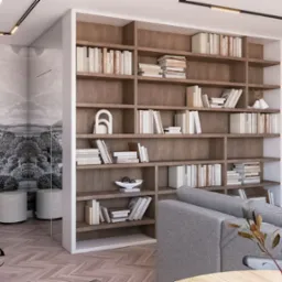 Nowoczesny salon z regałem na książki w zabudowie, tapetą w stylu vintage przedstawiającą krajobraz i szarą sofą. Na półkach książki, dekoracje, a na pierwszym planie wazon z gałązkami.