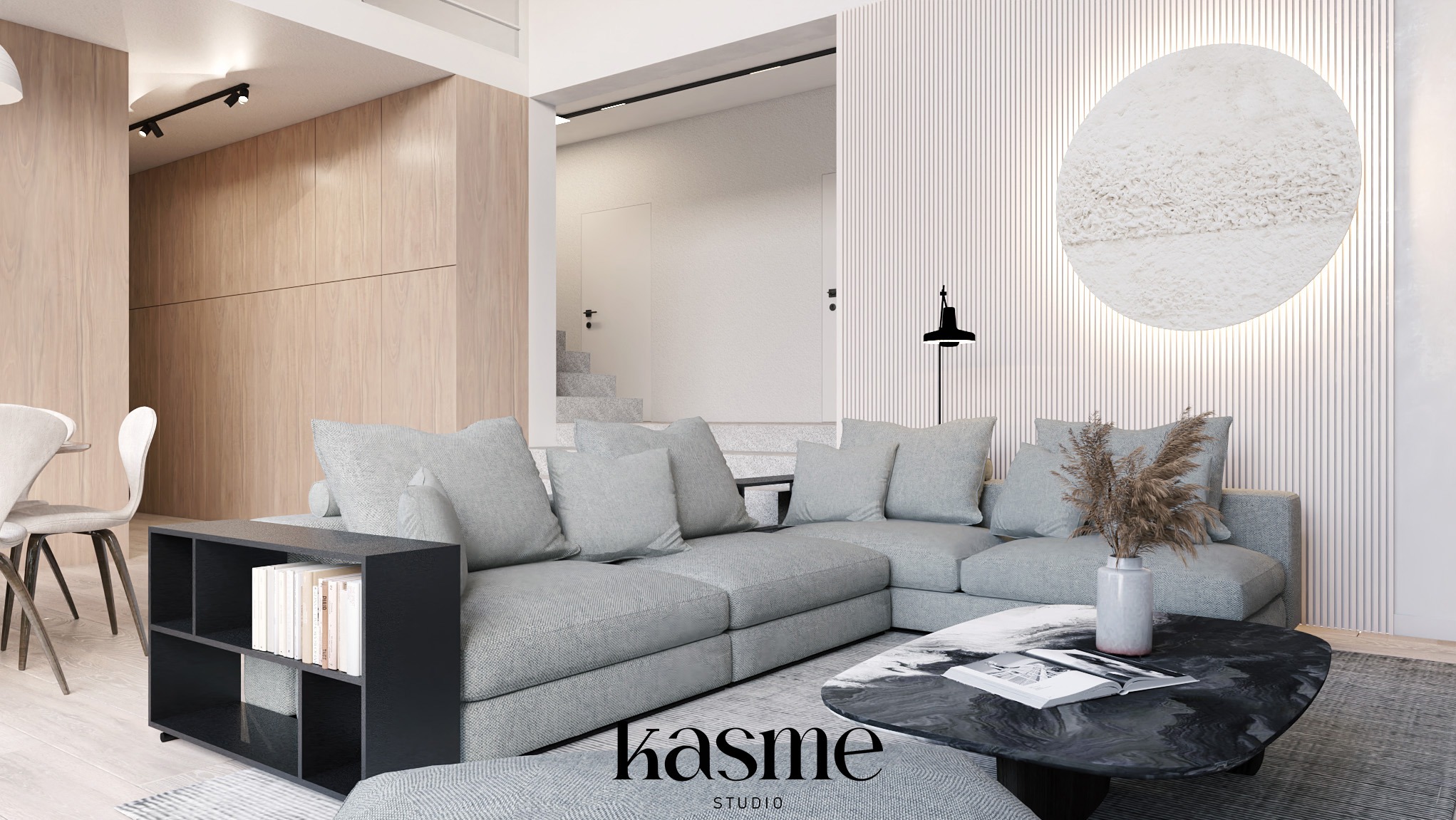Jasne wnętrze salonu z szarą sofą narożną, okrągłym stolikiem kawowym z czarnym marmurowym blatem, dekoracyjną lampą podłogową i okrągłą ozdobą ścienną na tle pionowych paneli ściennych.
