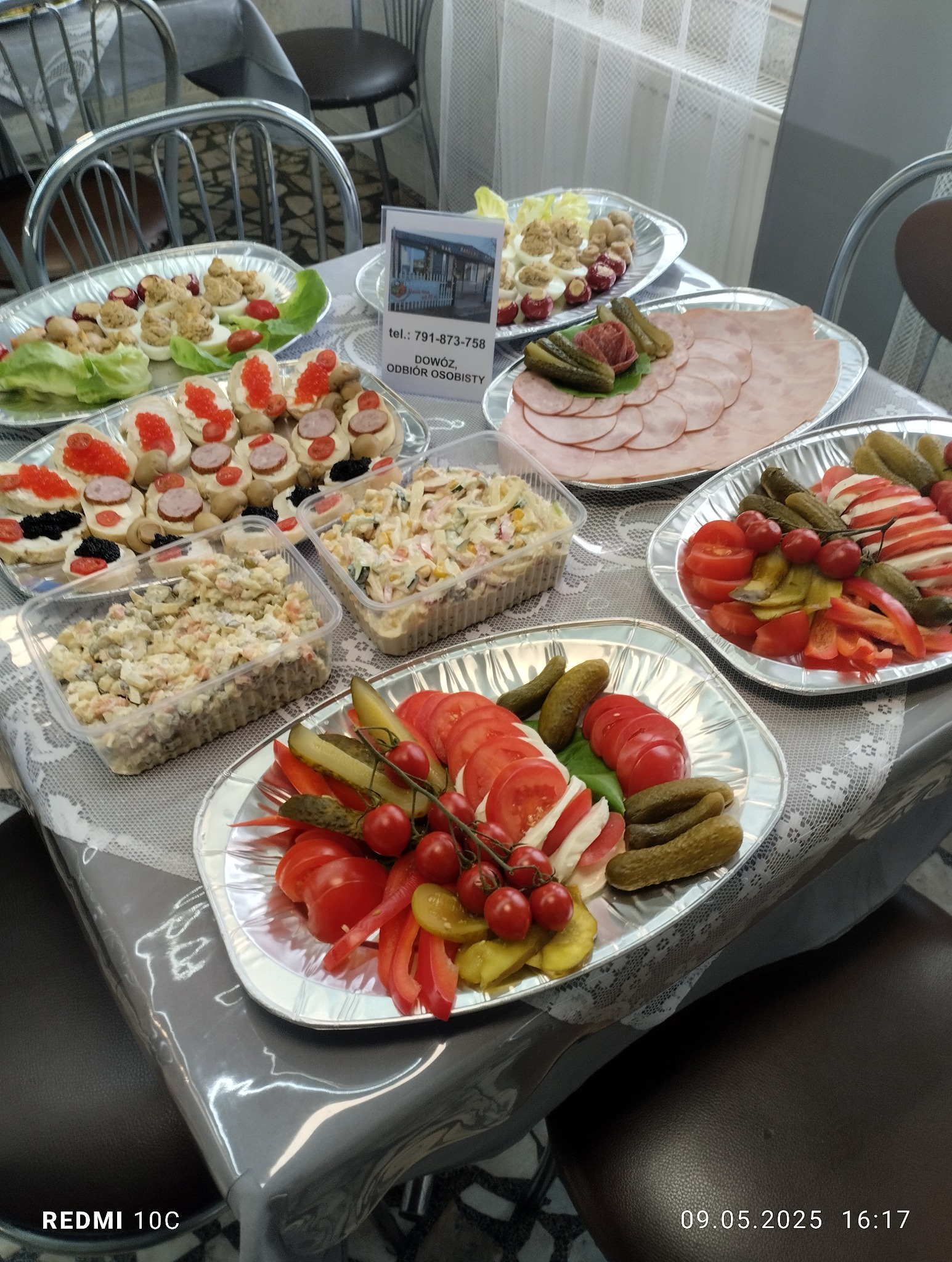 Stół z przekąskami: sałatki, koreczki, wędlina i warzywa na srebrnych tacach. Catering w Inowrocławiu, widok z góry, różnorodne kompozycje i tekstura potraw.