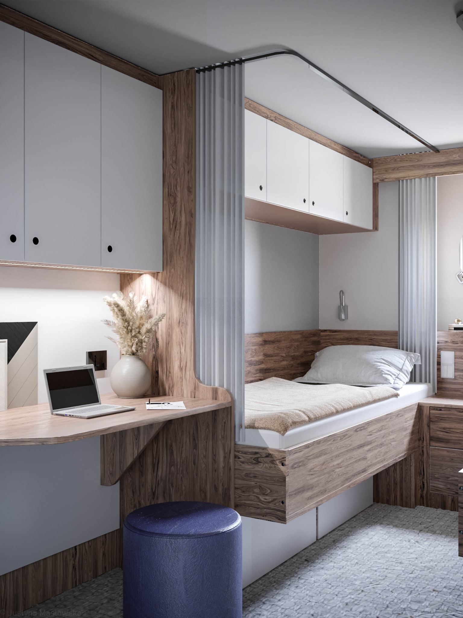 Kompaktowa sypialnia z biurkiem: białe szafki, drewniane akcenty, laptop na blacie, dekoracyjna trawa w wazonie i niebieski taboret.